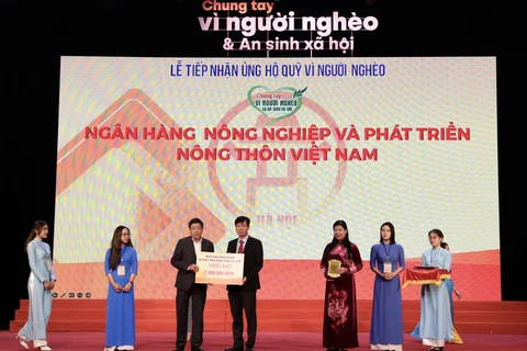 Ông Phạm Đức Tuấn - Phó Tổng giám đốc, Chủ tịch Công đoàn Agribank trao 2 tỷ đồng cho Quỹ “Vì người nghèo. (Ảnh: Vietnam+)