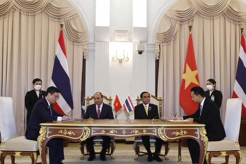 Ông Nguyễn Thanh Tùng, Phó Tổng Giám đốc phụ trách Ban điều hành Vietcombank (bên trái) và ông Ts. Rak Vorrakitpokatorn, Tổng Giám đốc Eximbank Thái Lan (bên phải) ký kết thỏa thuận hợp tác trước sự chứng kiến của Chủ tịch nước Cộng hòa XHCN Việt Nam Nguy