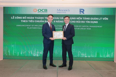 Ông Lê Thanh Quý Ngọc – Giám đốc khối Quản lý Rủi ro OCB nhận giấy chứng nhận hoàn thành triển khai và áp dụng nền tảng quản lý vốn theo Basel II nâng cao từ Moody’s Analytic . (Ảnh: Vietnam+)