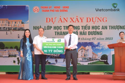 Đại diện Vietcombank, ông Nguyễn Xuân Cao Cường - Giám đốc Vietcombank Hải Dương trao biển tượng trưng tài trợ kinh phí xây dựng trường cho đại diện lãnh đạo UBND thành phố và hiệu trưởng trường tiểu học An Thượng. (Ảnh: Vietnam+)