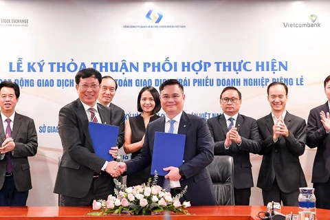 Ông Nguyễn Thanh Tùng - Tổng Giám đốc Vietcombank (bên phải) và ông Dương Văn Thanh - Tổng Giám đốc VSDC ký kết thỏa thuận phối hợp. (Ảnh: PV/Vietnam+)