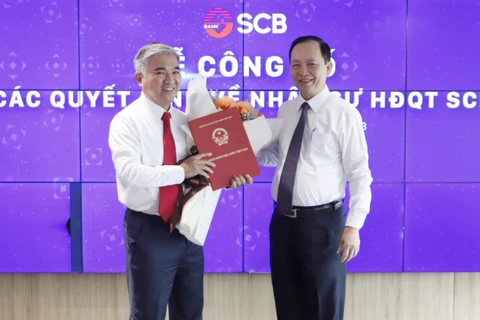 Phó Thống đốc Thường trực NHNN Đào Minh Tú trao quyết định trưng tập, chỉ định ông Phan Đình Điền giữ chức Chủ tịch HĐQT SCB. (Ảnh: PV/Vietnam+)