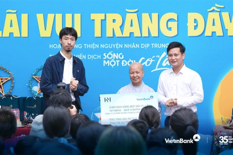 Đại diện VietinBank cùng Nghệ sĩ Rapper Đen Vâu trao tặng quà cho các em nhỏ tại Mái ấm Diệu Giác. (Ảnh: Vietnam+)