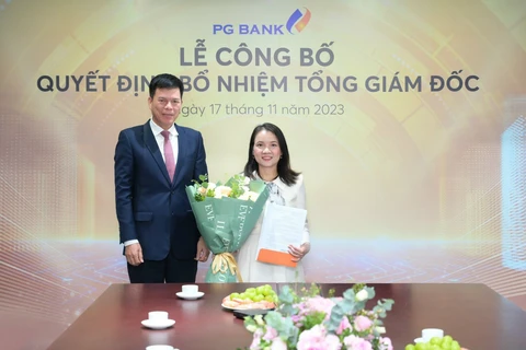 Ông Phạm Mạnh Thắng - Chủ tịch Hội đồng quản trị PGBank trao quyết định bổ nhiệm chức danh Tổng Giám đốc cho bà Đinh Thị Huyền Thanh. (Ảnh: PV/Vietnam+)