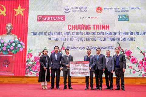 Ông Phạm Đức Ấn - Chủ tịch Hội đồng thành viên Agribank trao tặng quà của Agribank hỗ trợ hộ cận nghèo, đối tượng chính sách quận Hà Đông (Hà Nội) nhân dịp Tết Nguyên đán Giáp Thìn. (Ảnh: PV/Vietnam+)