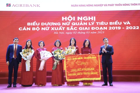 Đảng ủy - Hội đồng thành viên - Ban điều hành Agribank trao tặng Phụ nữ Agribank 8 chữ vàng: Năng động – Sáng tạo – Nhân hậu – Đảm đang. (Ảnh: Vietnam+)