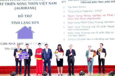 Đại diện Agribank - Đ/c Phùng Thị Bình Phó Tổng Giám đốc (thứ 5 từ trái sang) trao biểu trưng tài trợ 10 tỷ đồng (Ảnh: Vietnam+)