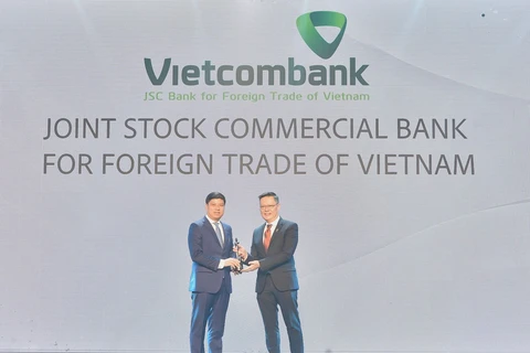 Ông Hồng Quang - Thành viên Hội đồng quản trị kiêm Giám đốc Khối Nhân sự đại diện Vietcombank nhận cúp vàng "Harmonia" từ Ban tổ chức. (Ảnh: Vietnam+)