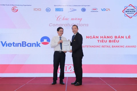 Ông Phạm Quốc Long (bên phải) - Giám đốc Trung tâm khách hàng phía Nam đại diện VietinBank nhận giải thưởng từ ban tổ chức. (Ảnh: Vietnam+)