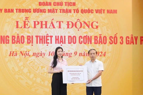 Phó Tổng Giám đốc Ngân hàng Chính sách Xã hội Nguyễn Thị Hằng (bên trái) trao biểu trưng cho đại diện lãnh đạo Mặt trận Tổ quốc Việt Nam. (Ảnh: Vietnam+)