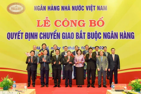 Phó Thủ tướng Chính phủ Hồ Đức Phớc cùng Ban lãnh đạo Ngân hàng Nhà nước chụp ảnh lưu niệm với lãnh đạo 4 ngân hàng. (Ảnh: Vietnam+)