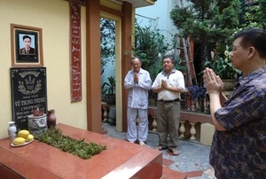 Tác giả kịch bản "Làm đĩ" cùng con rể và cháu của nhà văn Vũ Trọng Phụng bên mộ nhà văn chiều 12/5/2011 (ảnh: Nguyễn Anh/ Vietnam+)