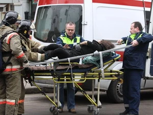 Chuyển một phụ nữ bị thương đi cấp cứu. (Ảnh: AFP/TTXVN). 