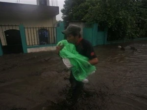 Một người dân ở Guatemala tránh bão. (Ảnh: AP).