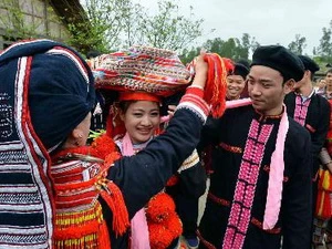 Mẹ chú rể bỏ khăn che mặt cho cô dâu trong đám cưới của người Dao. (Ảnh minh họa: Thanh Hà/TTXVN)
