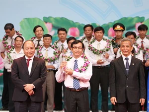 Phó Thủ tướng Nguyễn Xuân Phúc và ông Đặng Ngọc Tùng, Chủ tịch Tổng Liên đoàn Lao động Việt Nam trao giải thưởng cho các đại biểu. (Ảnh: Dương Giang/TTXVN)