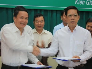 Tổng Giám đốc TTXVN (trái) và Chủ tịch UBND tỉnh Kiên Giang trao đổi Văn bản thỏa thuận tại lễ ký. (Ảnh: Lê Sen/TTXVN)