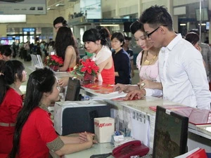 Khách hàng mua vé tại quầy của VietJetAir. (Ảnh: Hoàng Tuấn/Vietnam+)