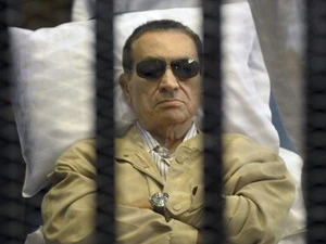 Cựu Tổng thống Ai Cập Hosni Mubarak nằm trong một buồng có chấn song trong phiên xét xử tại thành phố Cairo. (Nguồn: AP)