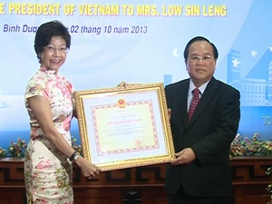 Chủ tịch UBND tỉnh Bình Dương Lê Thanh Cung đã trao Huy chương Hữu nghị tặng bà Low Sin Leng. (Ảnh: Dương Chí Tưởng/Vietnam+)