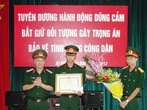 Thiếu tướng Phí Quốc Tuấn trao Bằng khen cho Thiếu úy Nguyễn Anh Tuấn (Ảnh: Sơn Bách/Vietnam+)