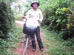 Vượt qua đường đá lởm chởm, nữ bưu tá miệt mài tập tễnh đạp xe đưa thư. (Ảnh: Thanh Tâm/Vietnam+)