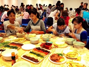 Các bạn trẻ Việt Nam tham gia làm các món ăn Hàn Quốc. (Ảnh: Thanh Hà/TTXVN)