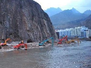 Nhân viên cứu nạn làm cạn nước đọng trong hồ rào chắn được tạo ra sau khi đất lở chặn sông Bạch Long. (Nguồn: XInhua)