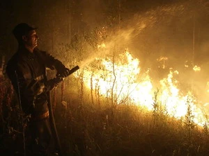 Nhân viên cứu hỏa phun nước dập đám cháy rừng gần làng Murmino, ngày 5/8. (Ảnh: AFP/TTXVN)