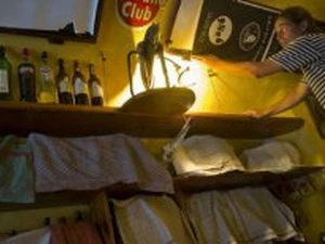 Người phục vụ quán rượu ở Prague đang dùng khăn che những chai rượu mạnh. (Nguồn: AFP)