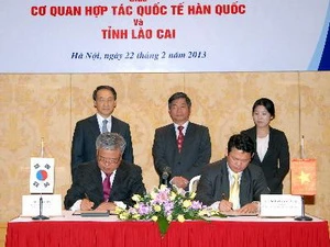 Ông Kim In (trái), đại diện KOICA và ông Nguyễn Văn Vịnh, đại diện tỉnh Lào Cai, ký Biên bản. (Ảnh: Danh Lam/TTXVN)