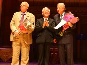Ông Lê Hoàng Quân (giữa), Chủ tịch UBND TP.HCM, tặng danh hiệu cao quý cho hai ông Len Aldis và Ben Chapman. (Ảnh: Lê Phương/Vietnam+)