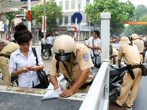 Cảnh sát giao thông Hà Nội lập biên bản với trường hợp vi phạm giao thông. (Ảnh: An Đăng/TTXVN) 