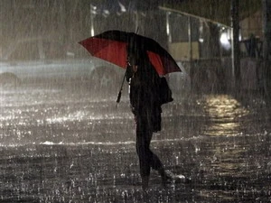 Một phụ nữ đi dưới trời mưa to ở Manila, Philippines ngày 23/6. (Nguồn: AP) 
