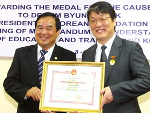 Thứ trưởng Giáo dục và Đào tạo Trần Quang Quý trao Kỷ niệm chương vì sự nghiệp giáo dục cho ông Kim Byung Kook. (Ảnh: Bích Ngọc/TTXVN) 