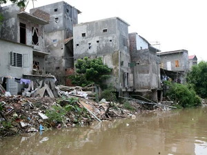 Các công trình nhà ở xâm phạm hành lang bảo vệ sông Nhuệ, tại thị trấn Cầu Diễn. (Ảnh: Xuân Trường/TTXVN)