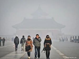 Khách du lịch đi bộ dưới làn sương mù ô nhiễm ở Bắc Kinh, ngày 12/1. (Nguồn: Xinhua) 