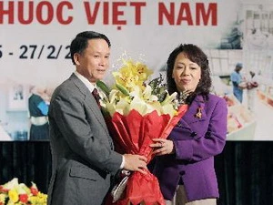 Tổng Giám đốc TTXVN Nguyễn Đức Lợi tặng hoa chúc mừng Bộ trưởng Bộ Y tế Nguyễn Thị Kim Tiến. (Ảnh: Dương Giang/TTXVN)