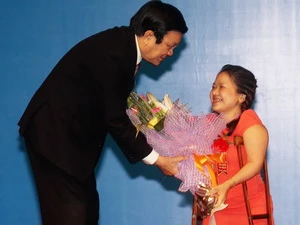 Chủ tịch nước Trương Tấn Sang tặng hoa cho đại biểu người khuyết tật Thành phố Hồ Chí Minh Nguyễn Thị Kim Chi. (Ảnh: Anh Tuấn/TTXVN)