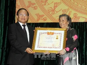 Bộ trưởng, Bộ Văn hóa, Thể thao và Du lịch trao danh hiệu nghệ sỹ ưu tú của cố nghệ sỹ Nguyễn Văn Hiệp cho đại diện gia đình nghệ sỹ. (Ảnh: Thanh Tùng/TTXVN)
