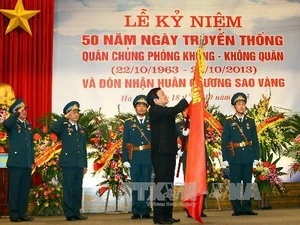 Chủ tịch nước Trương Tấn Sang gắn Huân chương Sao Vàng lên Cờ truyền thống của Quân chủng. (Ảnh: Trọng Đức/TTXVN)
