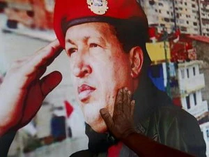Tay của một người dân chạm vào hình ảnh cố Tổng thống Hugo Chavez bên ngoài lăng mộ của ông. (Nguồn: Reuters)