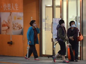 Người dân Đài Loan (Trung Quốc) đeo khẩu trang phòng cúm bên ngoài một bệnh viện. (Nguồn: AFP/TTXVN)