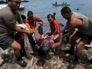 Lực lượng bảo vệ bờ biển Philippines chuyển thi thể một ngư dân vừa tìm thấy. (Ảnh: AFP/TTXVN)