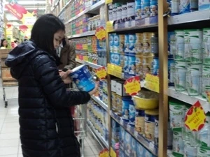 Người tiêu dùng lựa chọn mặt hàng sữa. (Ảnh: PV/Vietnam+)