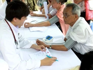 Bác sỹ Viện Tim mạch Việt Nam đo huyết áp cho bệnh nhân. (Ảnh: Dương Ngọc/TTXVN)