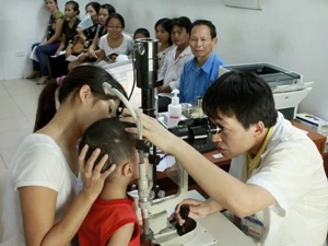 Bác sỹ khám cho bệnh nhân nhi đau mắt đỏ tại Hà Nội. (Ảnh: Dương Ngọc/TTXVN)
