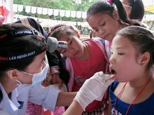 Bác sỹ kiểm tra sức khỏe răng miệng cho trẻ em. (Ảnh: Thế Anh/TTXVN)