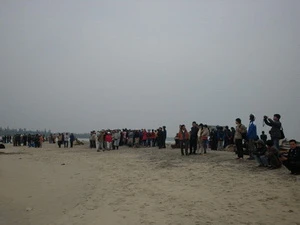 Người dân đứng trên bờ ngóng ra biển chờ tin tức từ các tàu cứu hộ. (Nguồn: NLĐ)