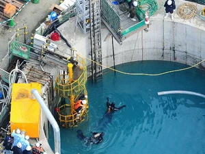 Các thợ lặn đang thâm nhập đường ống đứng để tìm kiếm các nạn nhân còn mất tích. (Ảnh: Cao Phong/Vietnam+)
